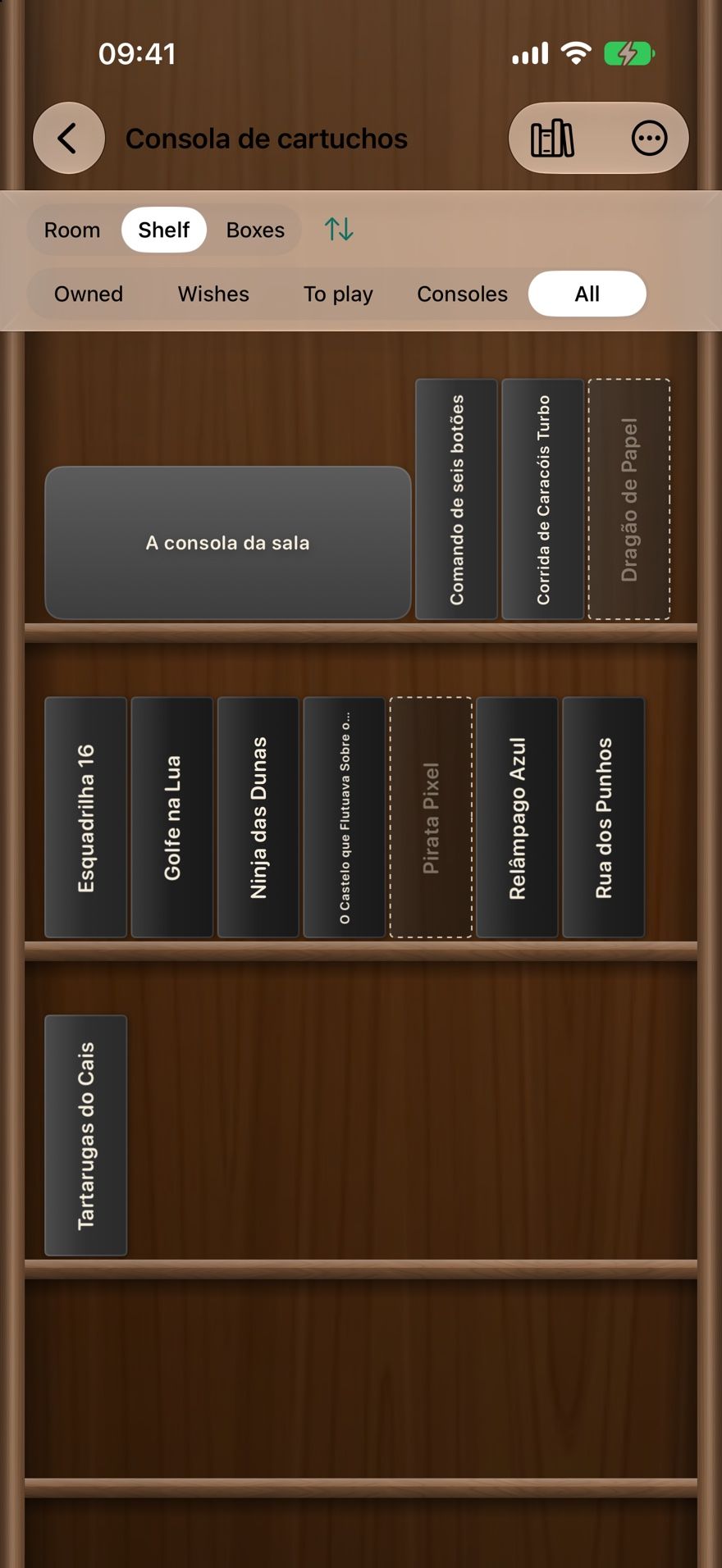 The games shelf in Collectors Den on iPhone, with a console and game spines standing on wooden shelves and dashed spines for wanted games.